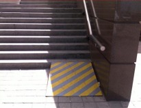 Wheelchair ramp placed at bottom of stairs.
