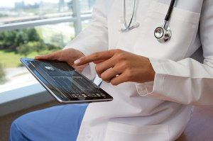 Doctor enters information into an iPad.