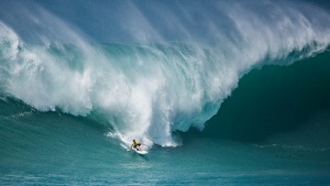 Surfer surfing a giant Hawaiian ocean wave.