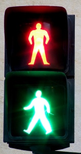 Stop sign shows a person light in green and a person lit in red.