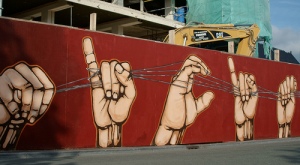 Street painting of sign language hand showing beginning of alphabet, A, B, C, D...