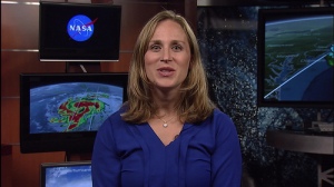 Female news broadcaster with image of Hurricane Matthew in the background.